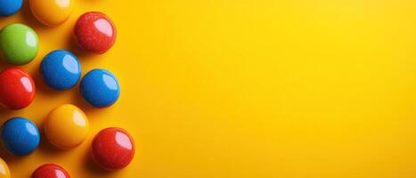 Flat Lay of Glossy Colorful Candies on a Bright Yellow Background with Copy Space photo