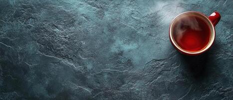 Steaming Cup of Tea on a Dark Textured Slate Background with Copy Space photo