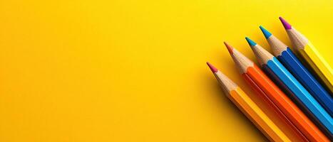 Vibrant Wooden Colored Pencils with Sharp Tips Arranged on a Bright Yellow Background with Copy Space photo