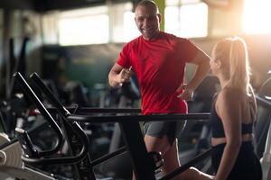 A couple working together in the gym, performing a conditioning workout side by side, supporting each other with strength, motivation, and teamwork. photo