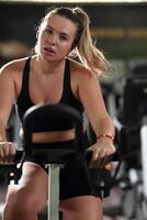 A focused fitness woman performing a conditioning workout in the gym, pushing her limits with strength, determination, and intense dedication. photo