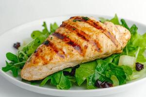 Grilled chicken breast served on fresh greens with vegetables photo