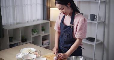 Handheld high angle view shot, Beautiful young woman is cut in stripes chicken wings with a knife on a wooden cutting board to make fried chicken at home. Cooking Concept ,Prepare food video