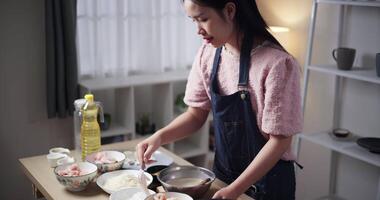 Handheld high angle view shot, Young Asian woman mixing chicken with crispy fried dough in bowl ready to cook. Cooking concept, Food preparation video