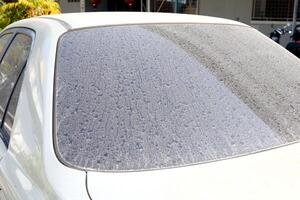 Dust on back windscreen of old retro style car and some spot of dry raindrops. photo
