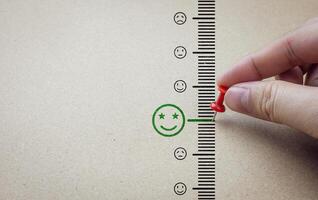 Hand use red pin marks at emoji excellent on paper background. concept of satisfaction level, service assessment, ratings positive customer reviews, with copy space photo