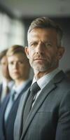 Confident mature man in formal suit leading a diverse team in a corporate environment photo