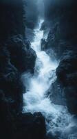 Majestic waterfall cascading through misty forest gorge in moody blue hues photo