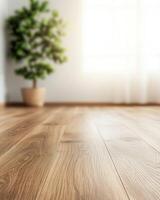 A bright, cozy room with wooden flooring features a potted plant, creating a warm and inviting atmosphere. photo