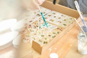 Crafting jewelry. mixing resin and botanical elements in molds for unique designs. photo
