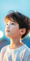 Asian child gazing upwards in a serene outdoor setting during twilight photo