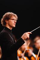 Young Conductor Leading an Orchestra with Passion and Precision photo