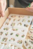 Close up of hands creating miniature figures with molds and tools for artistic crafts. photo