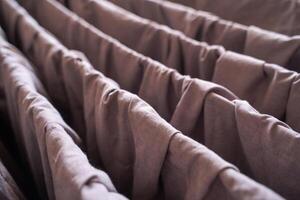 Close up of brown fabric folds with textured surface and soft creases in natural light. photo