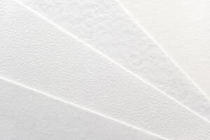 Close-up of textured white paper sheets arranged in a fan pattern. photo
