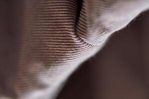 Close up detail of beige textured fabric with visible ribbed pattern and soft wrinkles. photo