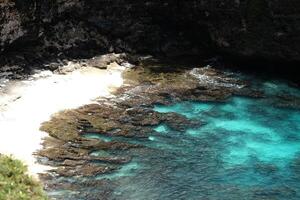 Beautiful landscape aerial view sea rocky beach waves and aqua surface water. Travel destination seascape of summer calm ocean in Bali at Indonesia photo
