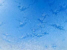 Ice crystals creating beautiful frozen patterns on window in winter photo