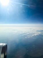 Airplane engine flying above the clouds at sunrise photo