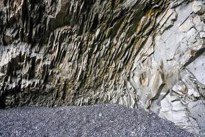 Basalt rock formations creating a natural shelter on a black sand beach in iceland photo