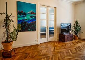 Riga, Latvia, 2024 - Interior with Herringbone Floor and Abstract Landscape Painting photo