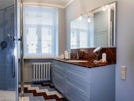 Riga, Latvia, 2024 - Modern Bathroom with Marble Vanity and Geometric Tiled Floor photo