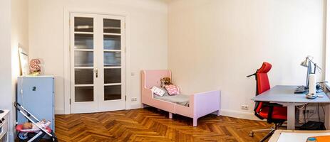 Riga, Latvia, 2024 - Minimalist Room with Pink Bed and Modern Desk Setup photo