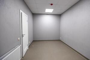 Riga, Latvia, 2024 - Empty Room with Gray Walls and White Tiled Ceiling photo