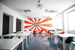 Riga, Latvia, 2024 - Modern Room with Bold Red and White Ray Design and Projector photo