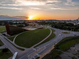 Riga, Latvia, 2024 - Ventspils Concert Hall Latvija at Sunset with Industrial Port View photo