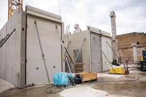 Urban Construction Site with Prefabricated Concrete Walls and Crane photo