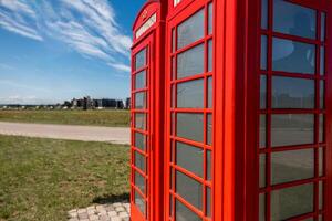 Red British Telephone Booths with Modern Buildings in the Distance photo