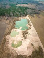 Aerial View of Sand Quarry with Turquoise Pools and Surrounding Forest photo