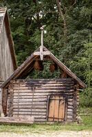 Rustic Wooden Log Structure with Decorative Roof Edging in Forest photo
