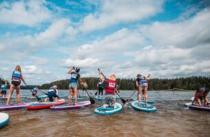 Paddleboarding Event on Calm Water with Forested Shoreline photo