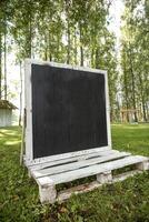 Outdoor Blackboard with Wooden Frame in a Grassy Park Setting photo