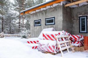 Partially Constructed Building in Snow Covered Forest Setting photo