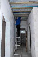 Person Working on Ceiling in Partially Constructed Building photo