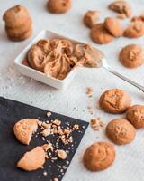 Close Up of Creamy Peanut Butter with Cookies on White Surface photo