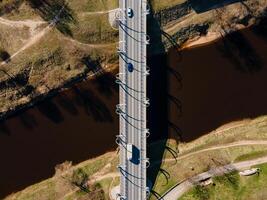 Aerial View of Modern Bridge with Curved Supports Over a Calm River photo