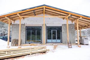 Partially Constructed Building with Snow Covered Ground and Trees photo