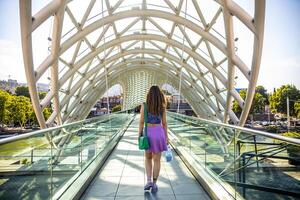 Woman Walking on the Bridge of Peace in Tbilisi, Georgia photo