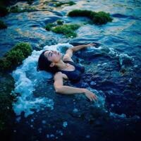 A woman laying in the water with her head up photo