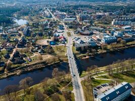Aerial View of a Small Town with Bridge and Surrounding Green Spaces photo