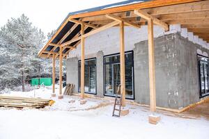 Partially Constructed Building in a Snowy Environment with Trees photo