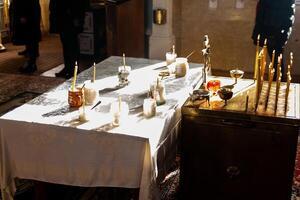 Lit Candles on a White Clothed Table in a Religious Setting photo