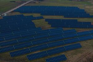Expansive Solar Farm with Rows of Blue Panels in Open Field photo