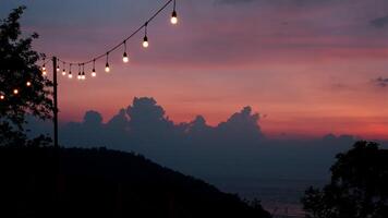 Sunset sky with string lights over ocean view video