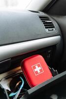 A bright red first aid kit can be found resting inside the glove box of a car, ready for any emergency that may arise while youre on the road or traveling to various destinations photo