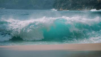 Powerful turquoise wave crashing on Kelingking Beach slow motion video